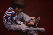 child tying his shoes 