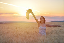 a woman standing in a golden wheat field 