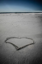heart drawn in the sand on a beach 