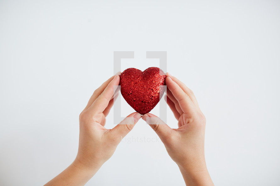 a woman up holding a red heart