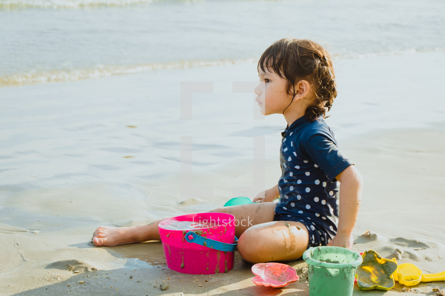 a child playing in the sand on a beach 