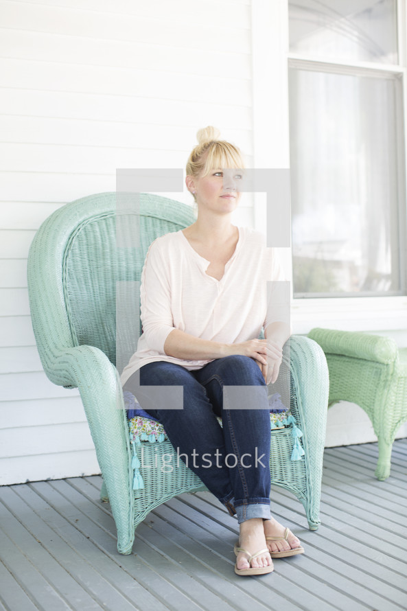 woman sitting in a chair on a front porch 