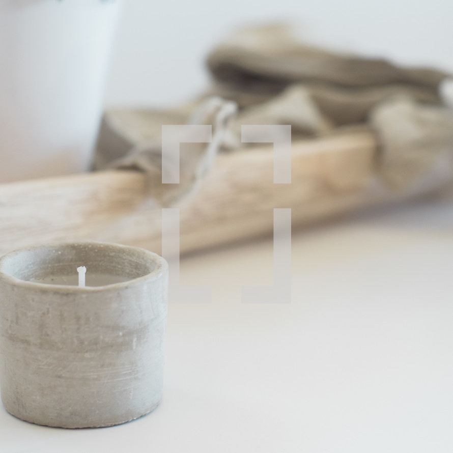 linen fabric on a wood tray and votive candle 