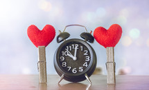 alarm clock and red hearts on clothespins 