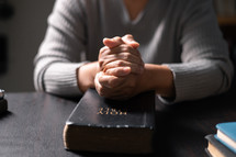 Woman praying on a Bible