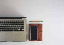laptop computer, cellphone, journal, pencil 