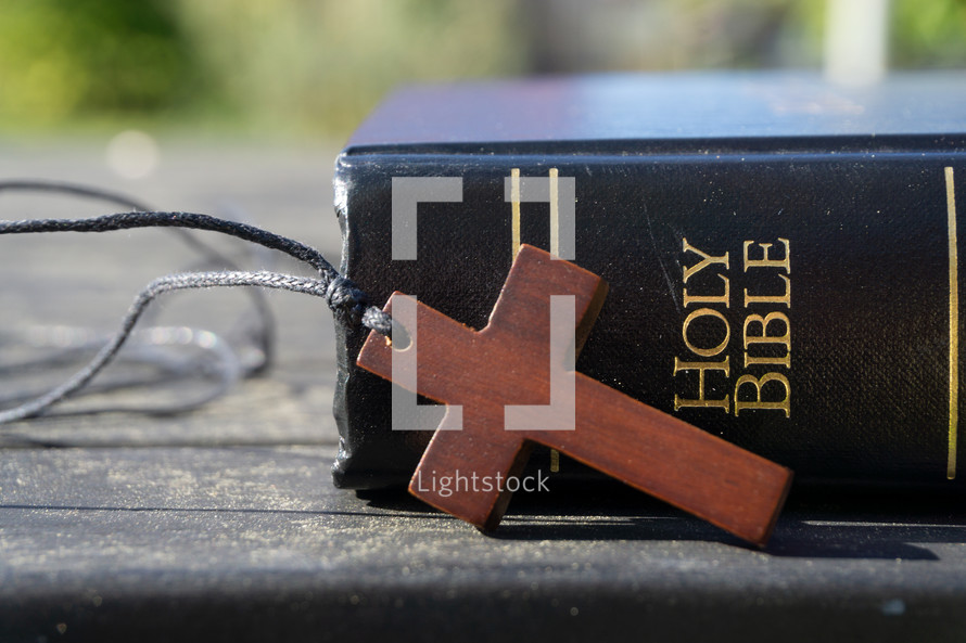 wooden cross necklace and Bible 