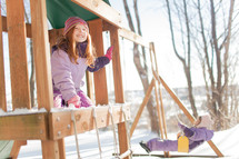 children on a backyard swing set in winter 