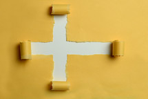 yellow ripped paper in the shape of a cross 