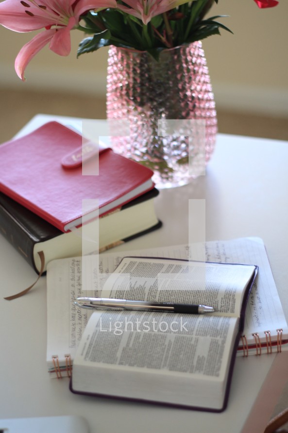 flowers in a vase and open Bible and journal on a table 