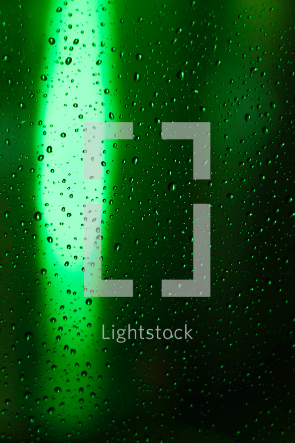 green bokeh light and rain drops on a window 