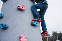 a child on a rock climbing platform on a playground 