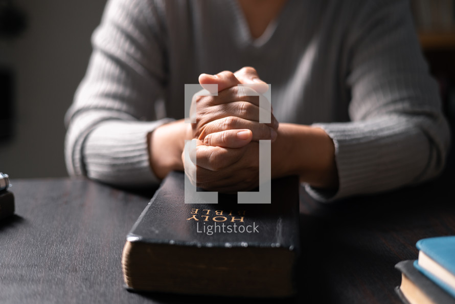 Woman praying on a Bible