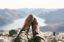 brown boots hanging over a mountainside 