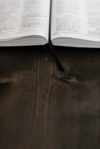 open Bible on a brown wood table 