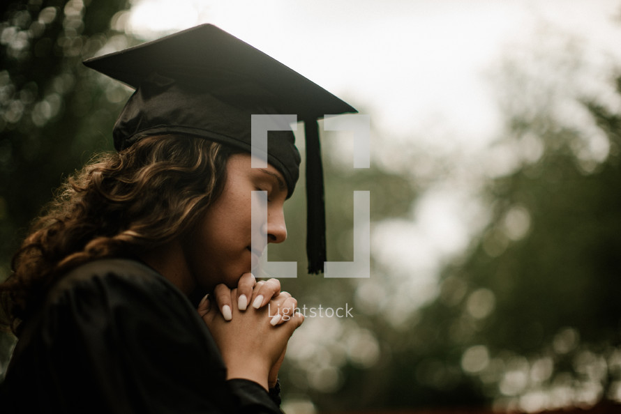 a praying female graduate 