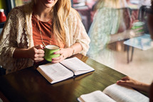 women reading and discussing scripture over coffee