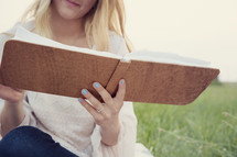 woman reading a journal outdoors 