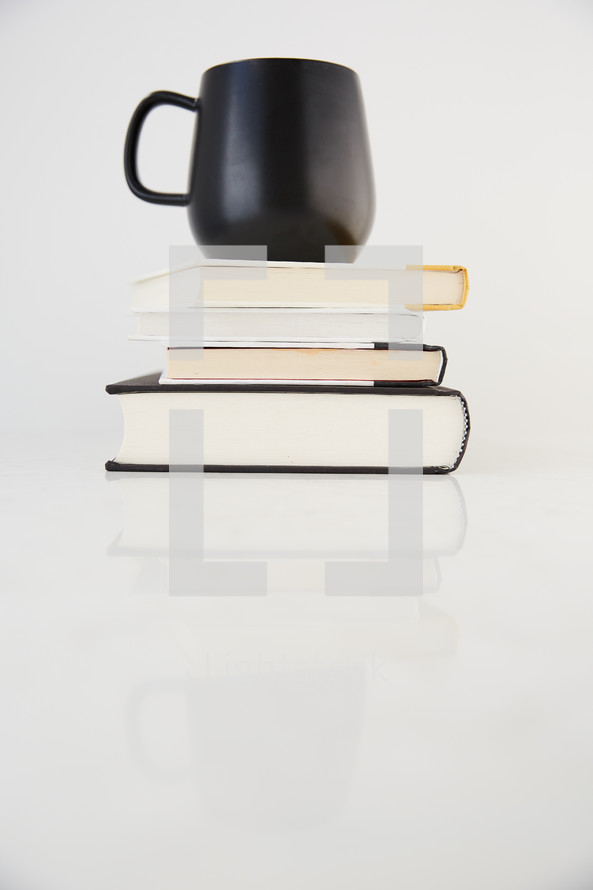 a coffee mug on a stack of books 