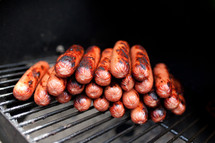 Hot dogs on a grill.