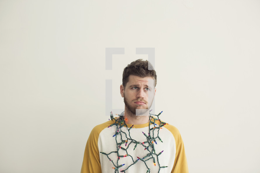 string of Christmas lights around a man's neck 
