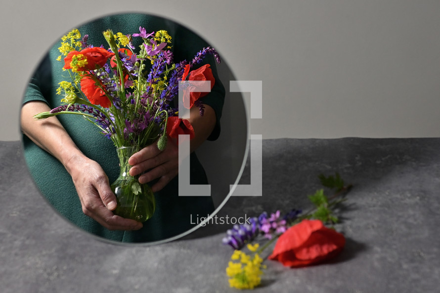 Woman Holding Different Flowers In Vase And Mirror reflection 