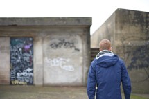 a man standing in front of graffiti covered wall 