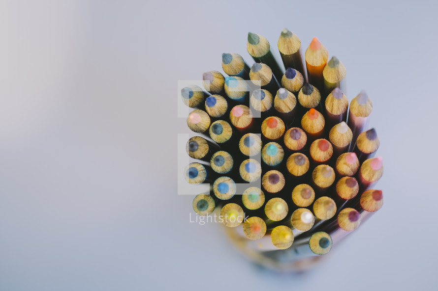Tips of colored pencils in a pencil holder.