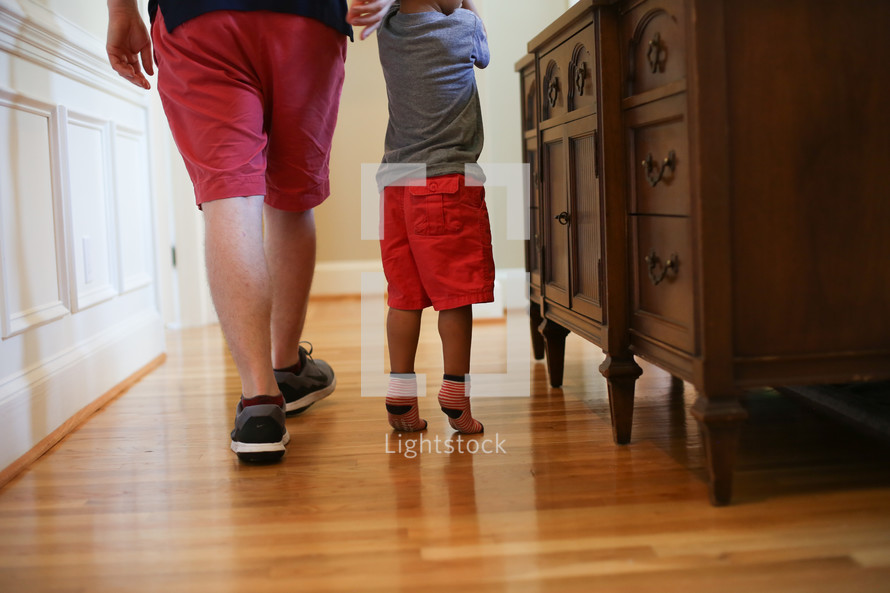 father and toddler son on a hardwood floor 