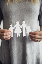 woman holding a paper cutout of a family