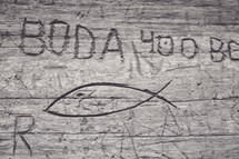 names and Jesus fish carved in wood 