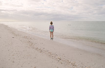 child standing on a beach 