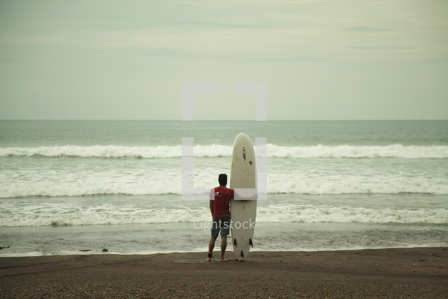 man on a beach with a surfboard 