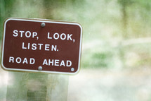 A brown sign reading, "Stop, Look, Listen.  Road Ahead."