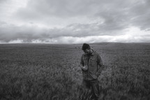 man standing alone in a field of wheat 