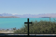 cross by a mountain lake shore 