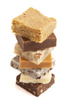 Chocolate fudge dessert squares on white background