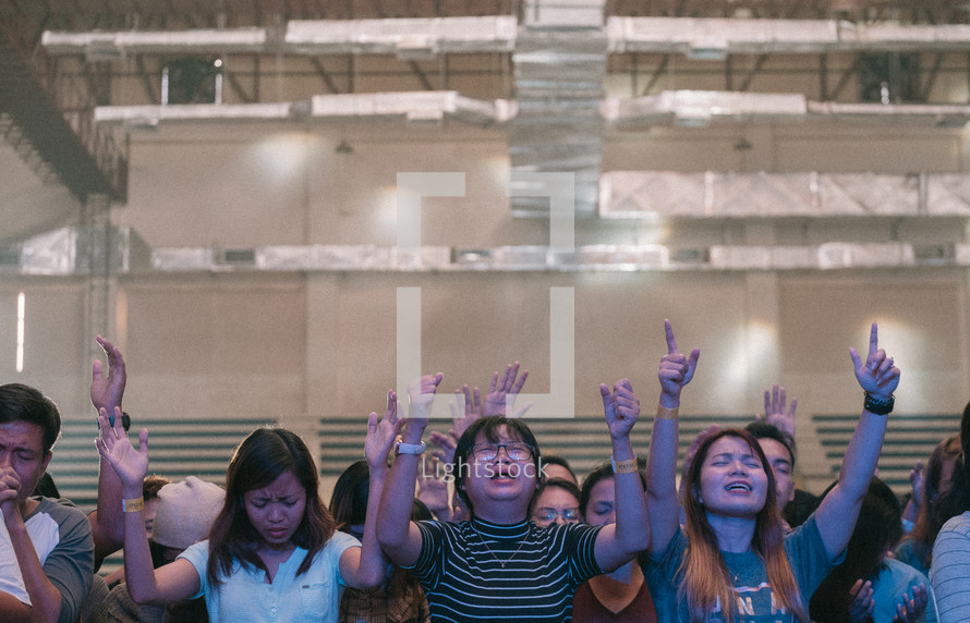 group with hands raised at worship service 