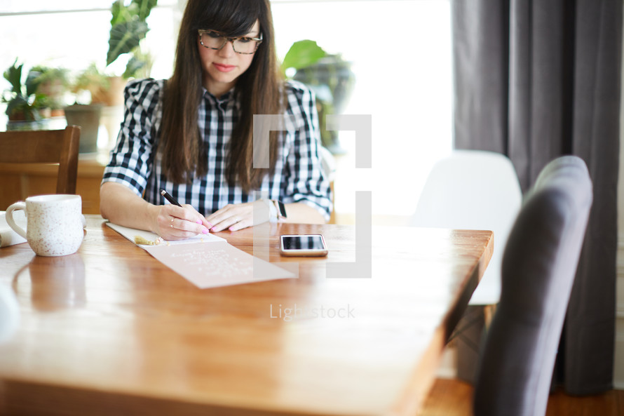 a woman sitting at a desk journaling 