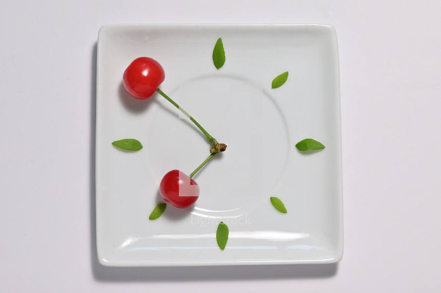 abstract cherry fruit clock isolated on plate, natural clock