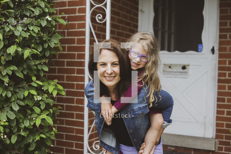 mother and daughter standing in front of a front door 