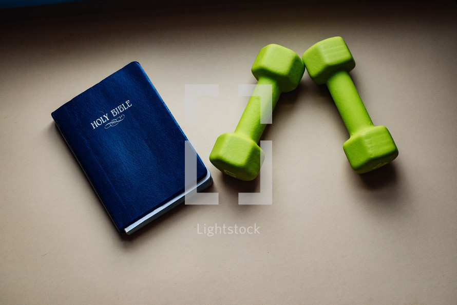 Holy Bible and hand weights 