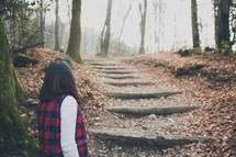 woman walking up stone steps on a trail 