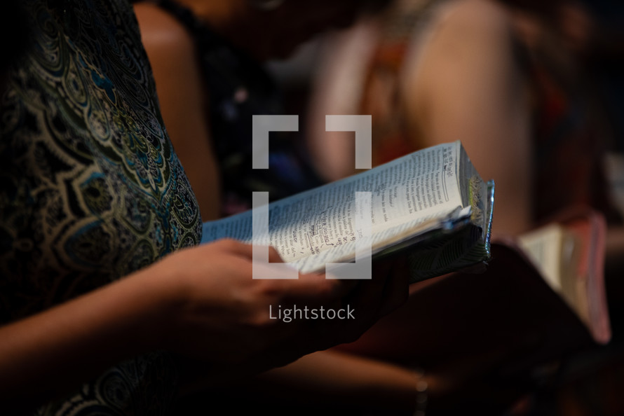 parishioners holding Bibles during a worship service 