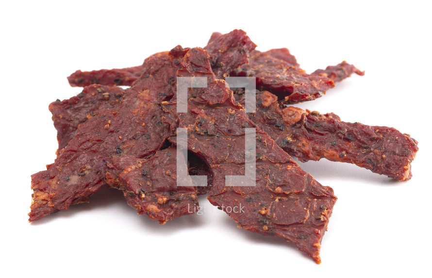 A Pile of Black Pepper Beef Jerky on a White Background