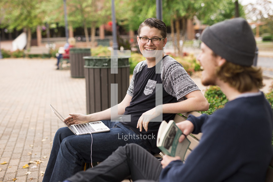 college students waiting on a bench 