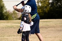 coach working with a female player on a boys Lacrosse team 
