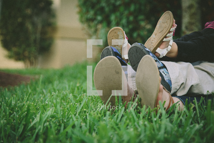 Mother, daughter, son's feet in grass 