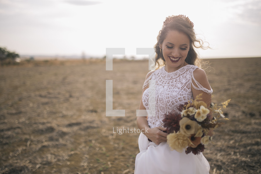 a bride holding a bouquet of fall flowers 