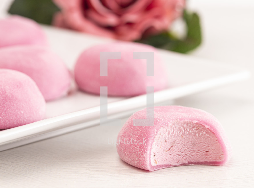 Pink Mochi Ice Cream with a Rose Flower on a White Table
